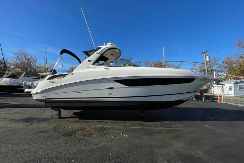  Yacht Photos Pics 2016 Sea Ray 310 Sundancer boat on display under clear blue sky.
