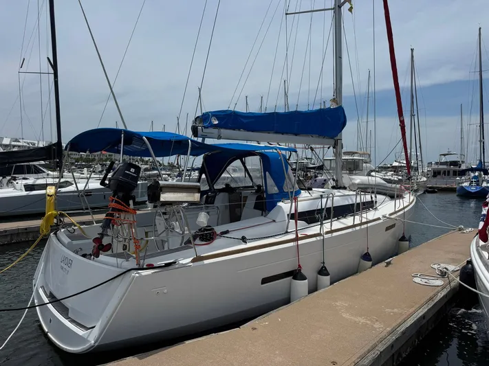 Layover Yacht Photos Pics 2018 Jeanneau Sun Odyssey 389 sailboat docked at marina, featuring blue covers and modern design.