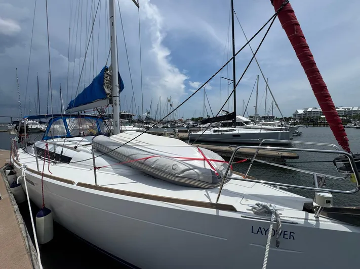 Layover Yacht Photos Pics 2018 Jeanneau Sun Odyssey 389 sailboat docked at marina under cloudy sky.