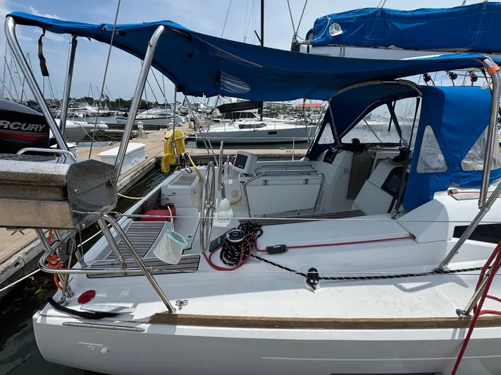 Layover Yacht Photos Pics 2018 Jeanneau Sun Odyssey 389 sailboat docked, featuring blue canopy and spacious cockpit.