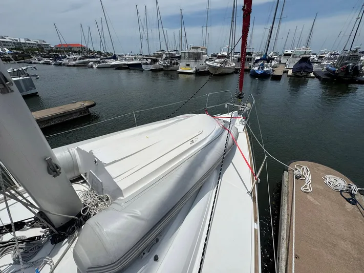 Layover Yacht Photos Pics 2018 Jeanneau Sun Odyssey 389 sailboat docked in a marina with other boats.