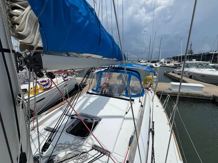 Layover Yacht Photos Pics 2018 Jeanneau Sun Odyssey 389 sailboat docked at marina under cloudy sky.
