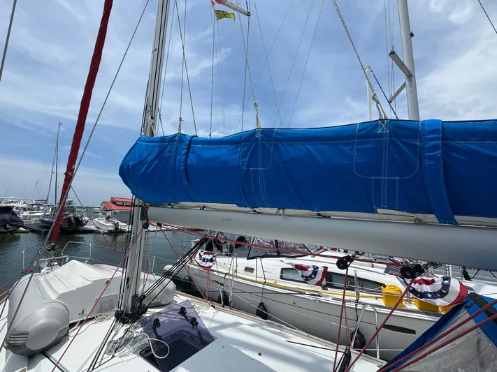 Layover Yacht Photos Pics 2018 Jeanneau Sun Odyssey 389 sailboat docked, featuring blue sail cover and marina background.