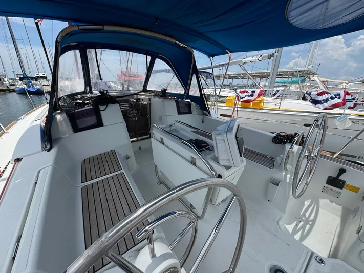 Layover Yacht Photos Pics 2018 Jeanneau Sun Odyssey 389 sailboat cockpit with dual steering wheels and blue canopy.