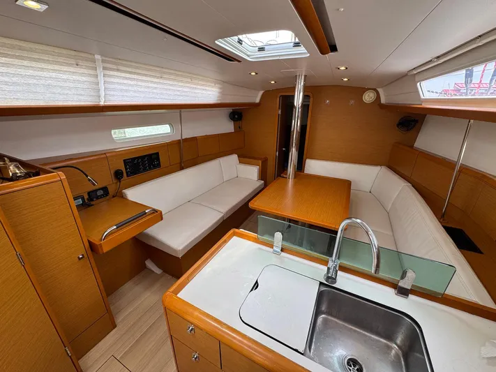 Layover Yacht Photos Pics Interior of 2018 Jeanneau Sun Odyssey 389 yacht with modern wood finish and seating area.