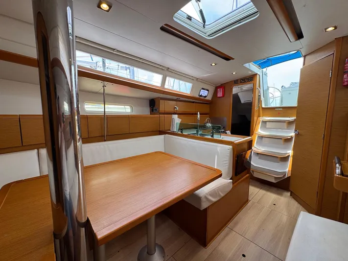 Layover Yacht Photos Pics Interior of 2018 Jeanneau Sun Odyssey 389 sailboat, featuring modern wood finish and seating area.