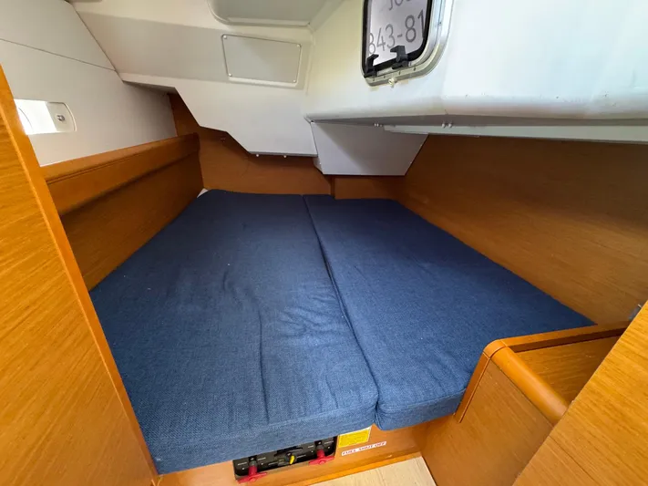 Layover Yacht Photos Pics Cozy cabin interior of 2018 Jeanneau Sun Odyssey 389 sailboat with blue cushions.