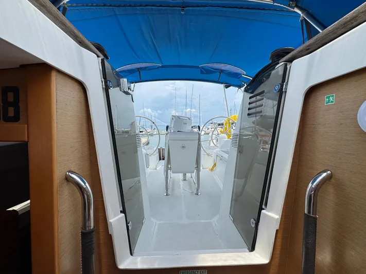 Layover Yacht Photos Pics 2018 Jeanneau Sun Odyssey 389 cockpit with blue canopy and dual steering wheels.