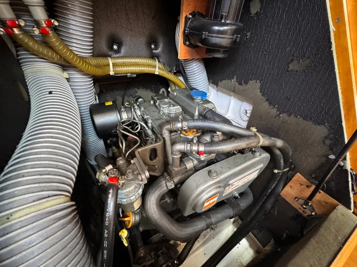 Layover Yacht Photos Pics Engine compartment of a 2018 Jeanneau Sun Odyssey 389 sailboat, showing hoses and mechanical components.