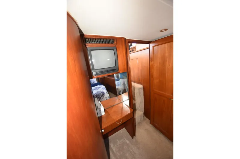 My Love Yacht Photos Pics 1993 Ocean Yachts 44 Aft Cabin interior with TV, wood cabinetry, and mirror.