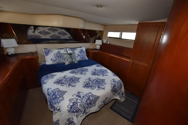 My Love Yacht Photos Pics 1993 Ocean Yachts 44 Aft Cabin bedroom with nautical-themed bedding and wooden cabinetry.