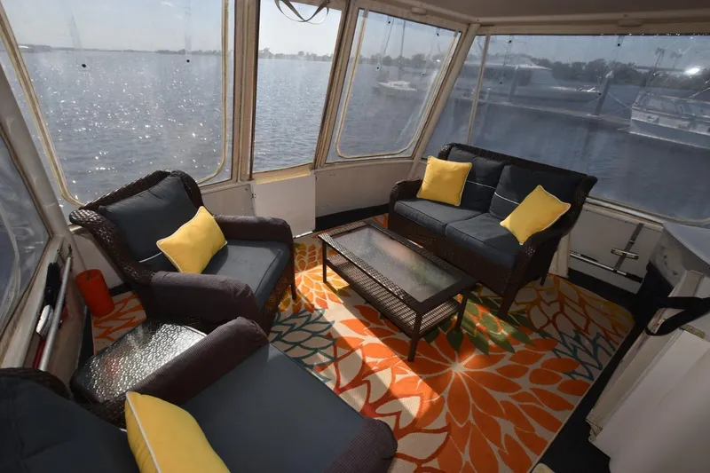 My Love Yacht Photos Pics 1993 Ocean Yachts 44 Aft Cabin interior with wicker furniture and colorful rug.