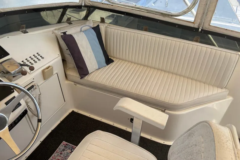 My Love Yacht Photos Pics 1993 Ocean Yachts 44 Aft Cabin helm with white seating and striped pillow.