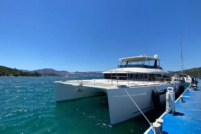  Yacht Photos Pics 2019 Lagoon 630 Motor Yacht docked on a sunny day with clear blue water.