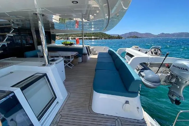  Yacht Photos Pics Luxurious 2019 Lagoon 630 Motor Yacht deck with seating, ocean view, and Honda outboard motor.