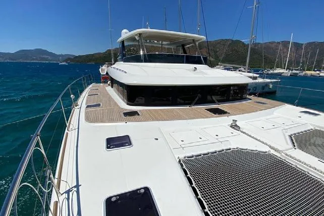  Yacht Photos Pics 2019 Lagoon 630 Motor Yacht on clear blue water, showcasing spacious deck and sleek design.