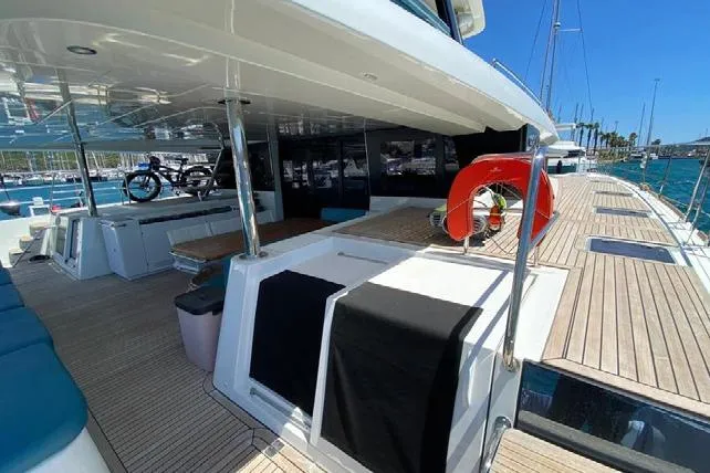  Yacht Photos Pics 2019 Lagoon 630 Motor Yacht deck with seating, life preserver, and ocean view.