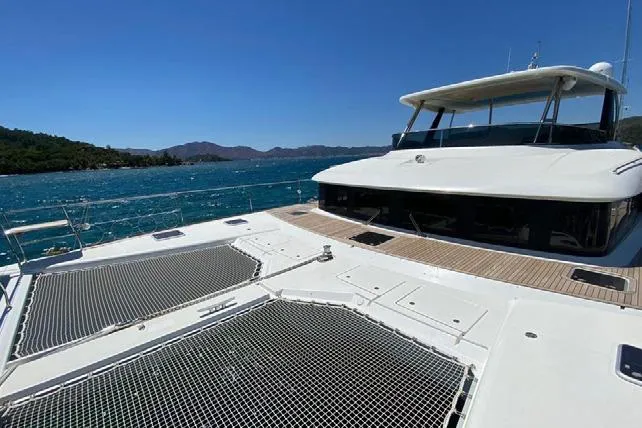  Yacht Photos Pics 2019 Lagoon 630 Motor Yacht cruising on clear blue waters under a sunny sky.