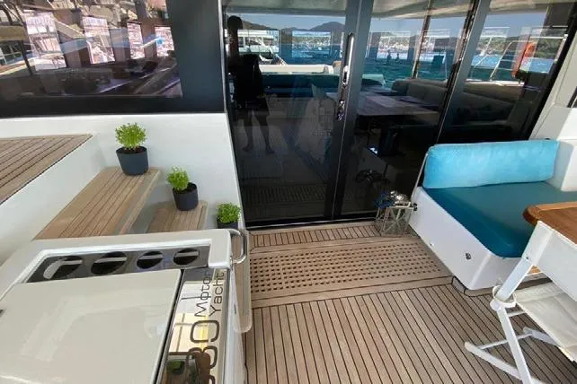  Yacht Photos Pics 2019 Lagoon 630 Motor Yacht interior with teak flooring, seating, and potted plants.