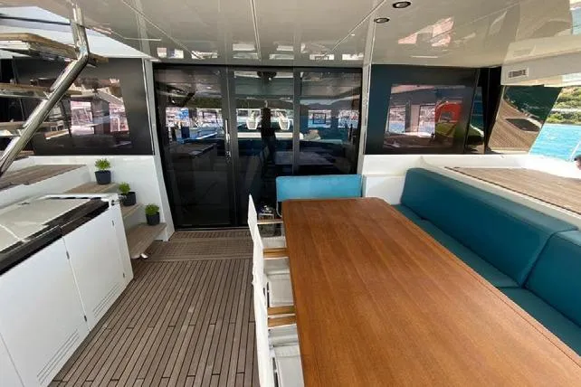  Yacht Photos Pics Spacious interior of 2019 Lagoon 630 Motor Yacht with elegant wooden table and seating.