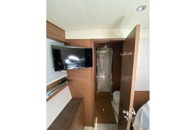  Yacht Photos Pics Interior of 2019 Lagoon 630 Motor Yacht with TV and bathroom view.