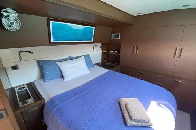  Yacht Photos Pics Luxurious bedroom interior of 2019 Lagoon 630 Motor Yacht with modern design and cozy bedding.