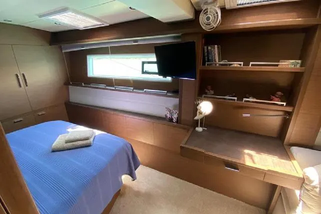  Yacht Photos Pics Luxurious cabin interior of 2019 Lagoon 630 Motor Yacht with bed, desk, and TV.