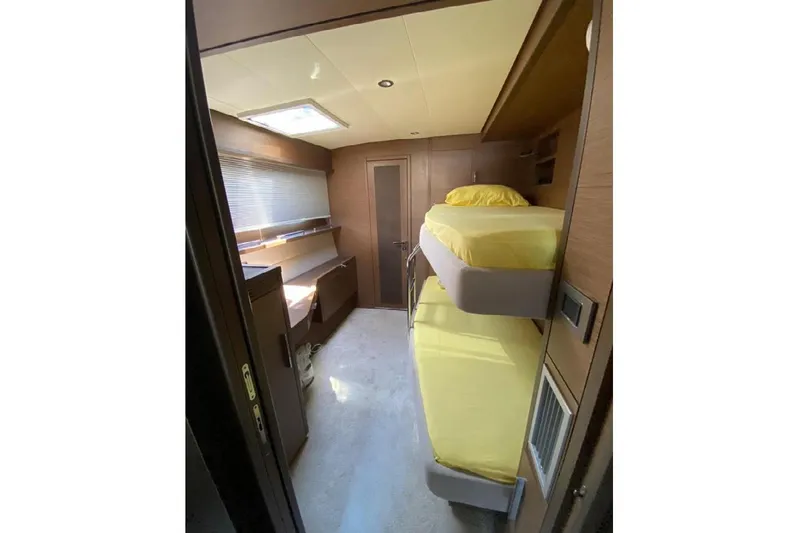  Yacht Photos Pics Interior of 2019 Lagoon 630 Motor Yacht cabin with bunk beds and yellow bedding.