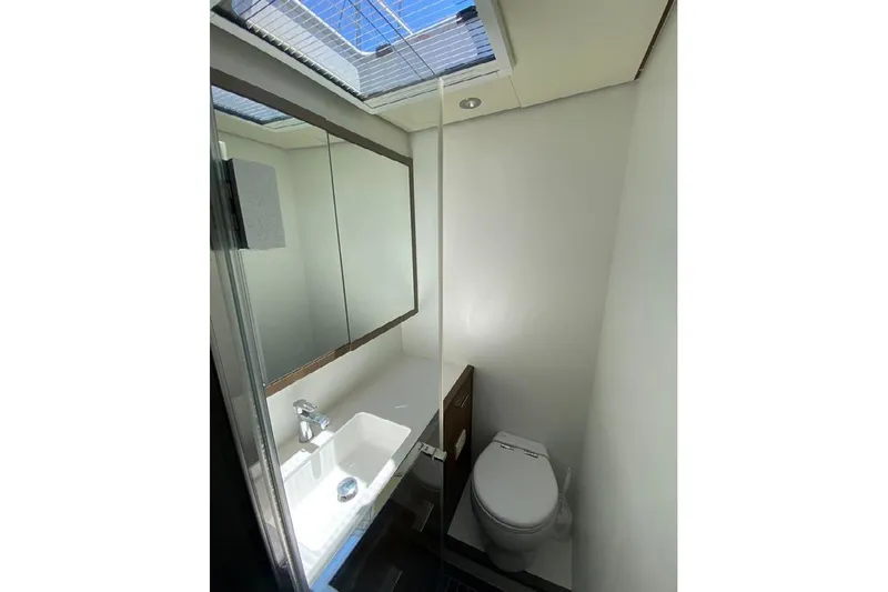  Yacht Photos Pics Bathroom interior of 2019 Lagoon 630 Motor Yacht with skylight and modern fixtures.