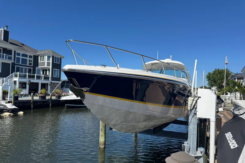  Yacht Photos Pics 2006 Formula 400 Super Sport boat docked near waterfront homes under clear blue sky.
