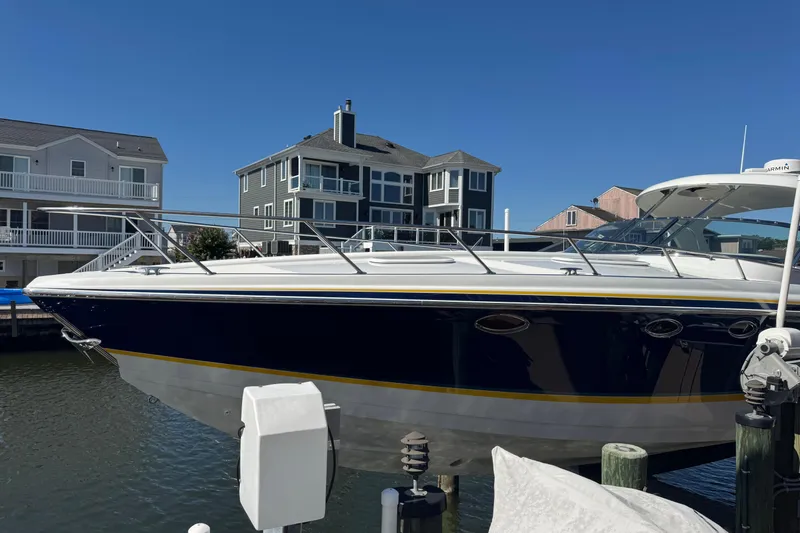  Yacht Photos Pics 2006 Formula 400 Super Sport boat docked near waterfront homes under clear blue sky.