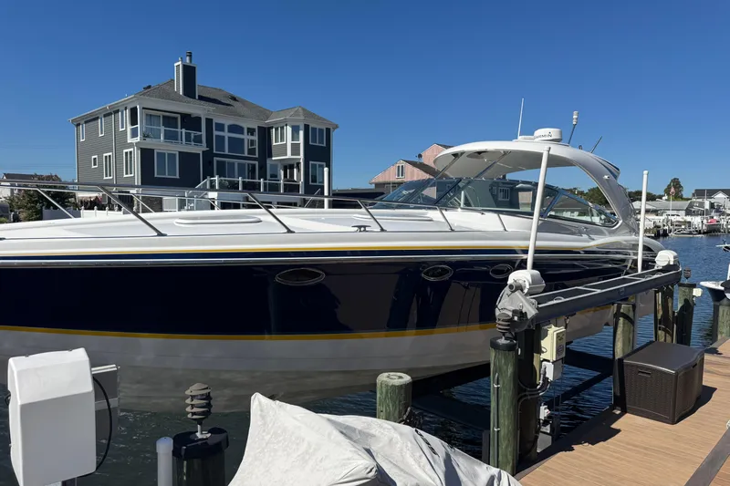  Yacht Photos Pics 2006 Formula 400 Super Sport boat docked near waterfront homes under clear blue sky.