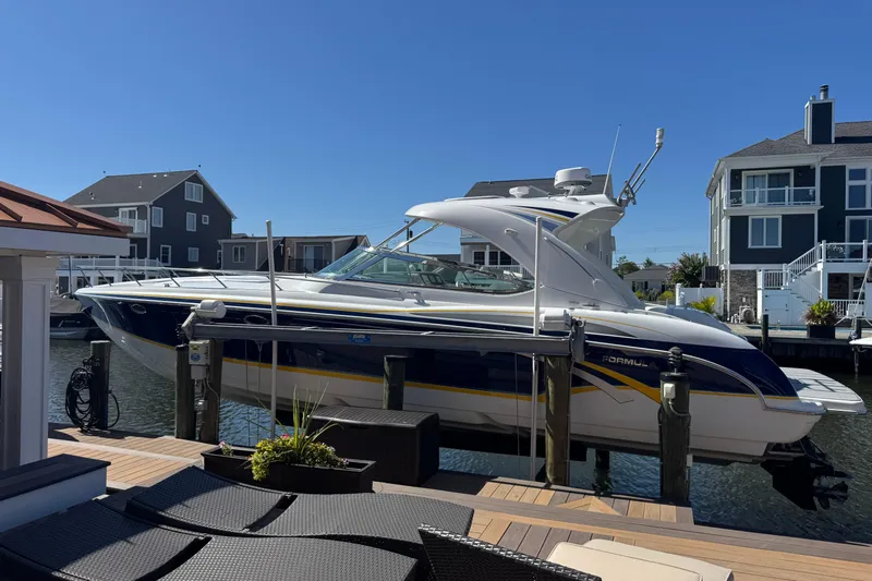  Yacht Photos Pics 2006 Formula 400 Super Sport boat docked in a residential marina under clear blue skies.
