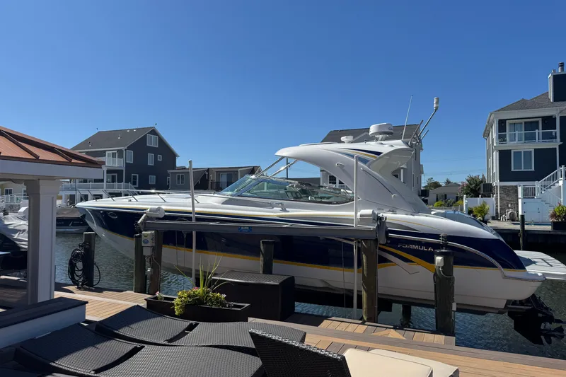  Yacht Photos Pics 2006 Formula 400 Super Sport boat docked in a residential marina under clear blue skies.