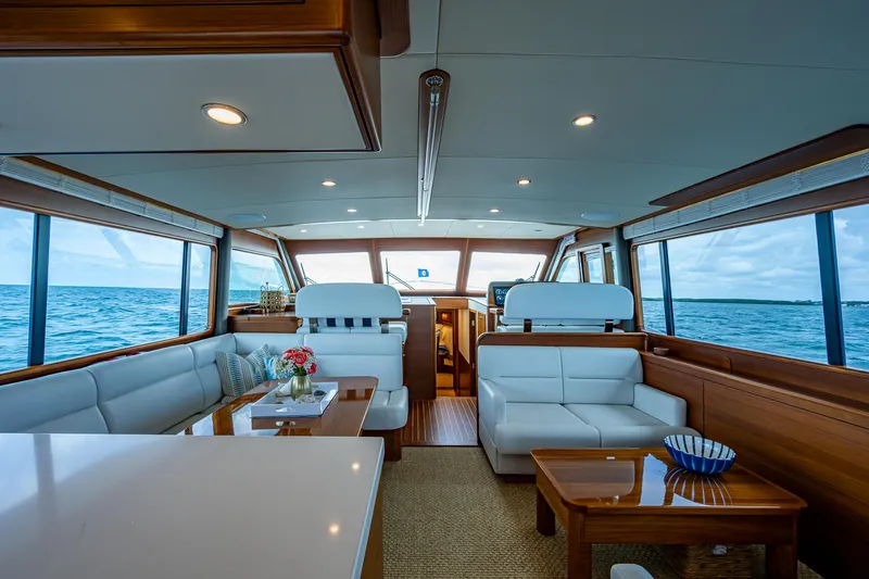 Painkiller Yacht Photos Pics Luxurious interior of 2023 Grand Banks GB60 yacht with ocean view and elegant furnishings.