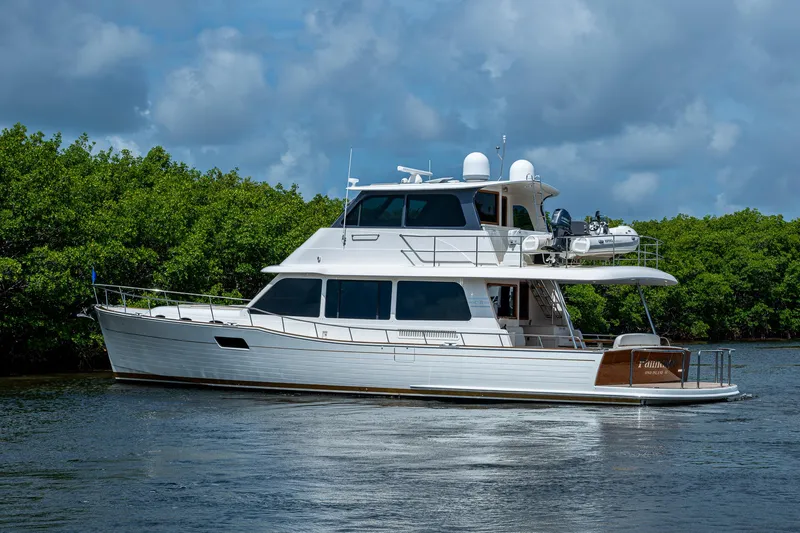 Painkiller Yacht Photos Pics 2023 Grand Banks GB60 yacht cruising on a serene waterway.