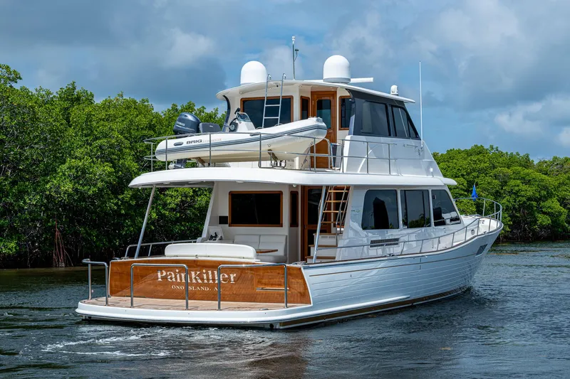 Painkiller Yacht Photos Pics 2023 Grand Banks GB60 yacht cruising on water, featuring sleek design and luxury amenities.