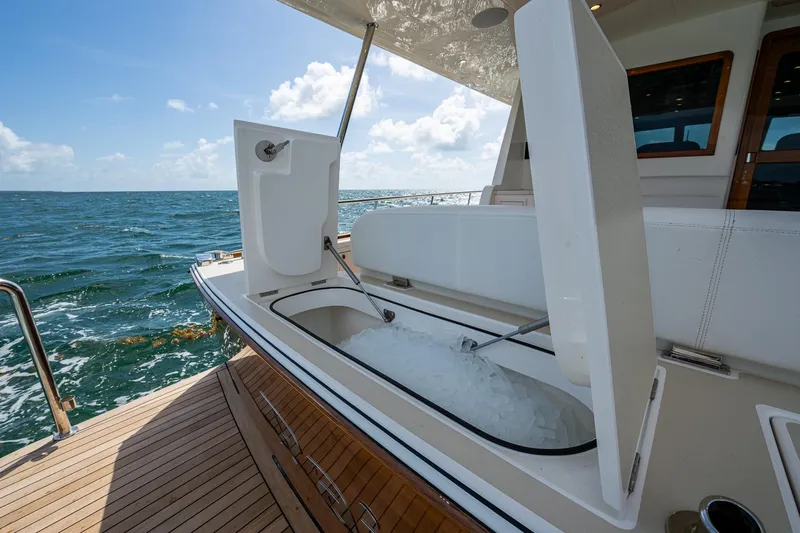 Painkiller Yacht Photos Pics 2023 Grand Banks GB60 yacht with open ice storage on deck, ocean view.