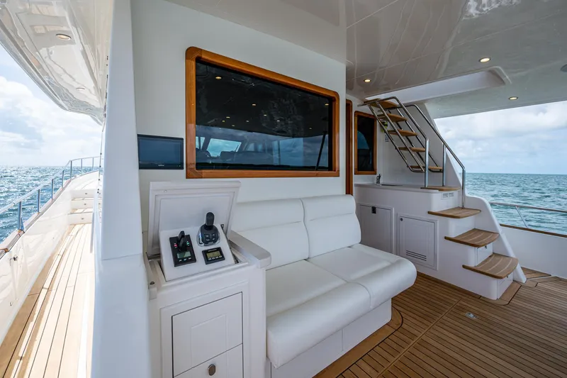 Painkiller Yacht Photos Pics Luxurious 2023 Grand Banks GB60 yacht interior with seating and stairs, overlooking the ocean.