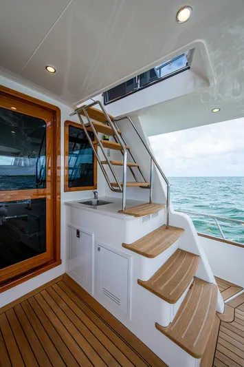 Painkiller Yacht Photos Pics Elegant 2023 Grand Banks GB60 yacht interior with wooden stairs and ocean view.