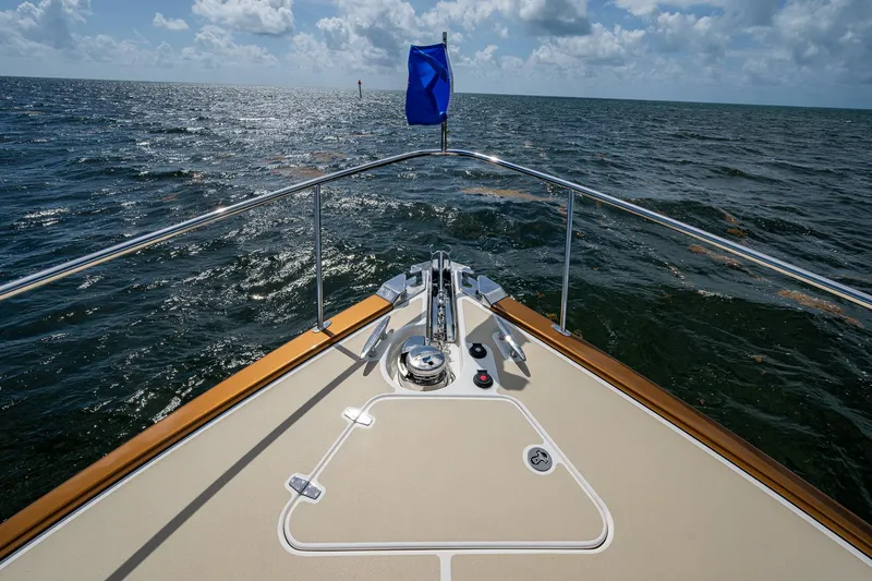 Painkiller Yacht Photos Pics Bow view of 2023 Grand Banks GB60 yacht on open sea under cloudy sky.