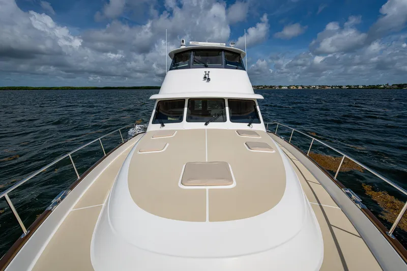 Painkiller Yacht Photos Pics 2023 Grand Banks GB60 yacht on open water under a partly cloudy sky.