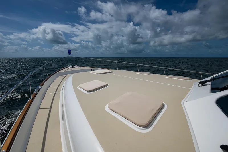 Painkiller Yacht Photos Pics 2023 Grand Banks GB60 yacht deck with ocean view under cloudy sky.
