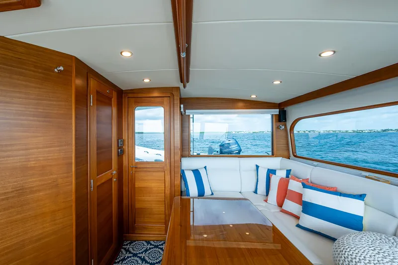 Painkiller Yacht Photos Pics Luxurious 2023 Grand Banks GB60 yacht interior with elegant wood finish and ocean view.