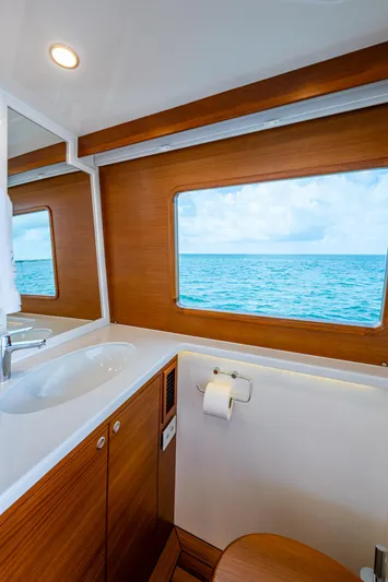 Painkiller Yacht Photos Pics Luxurious 2023 Grand Banks GB60 yacht bathroom with ocean view through large window.