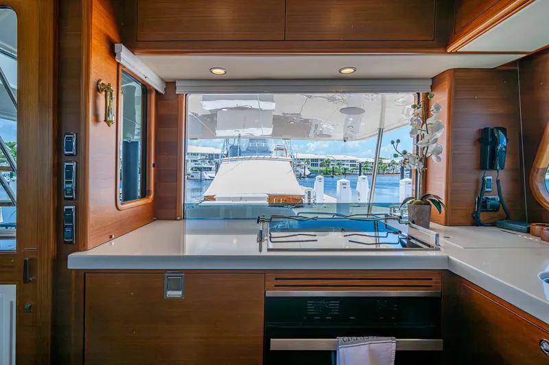 Painkiller Yacht Photos Pics Interior of 2023 Grand Banks GB60 yacht with modern kitchen and marina view.