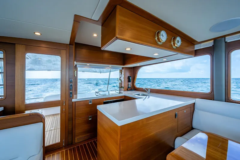 Painkiller Yacht Photos Pics Luxurious 2023 Grand Banks GB60 yacht interior with ocean view and elegant wood finishes.