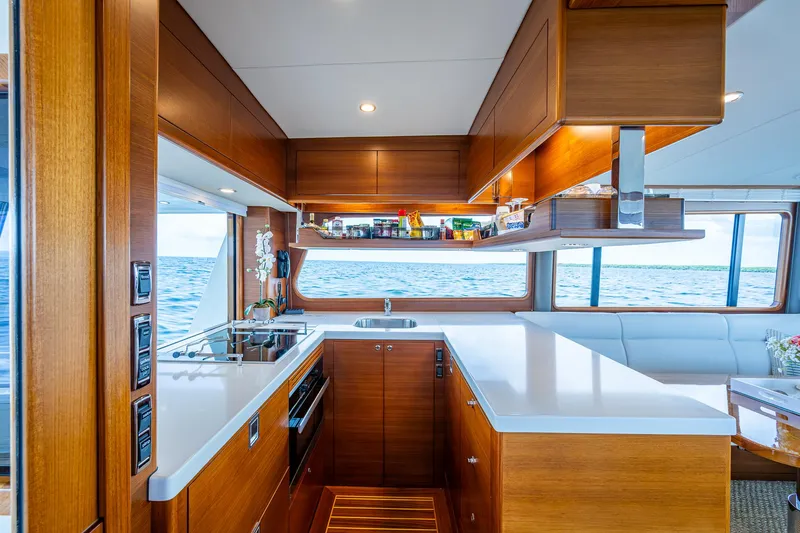 Painkiller Yacht Photos Pics Luxurious 2023 Grand Banks GB60 yacht kitchen with modern wood cabinetry and ocean view.