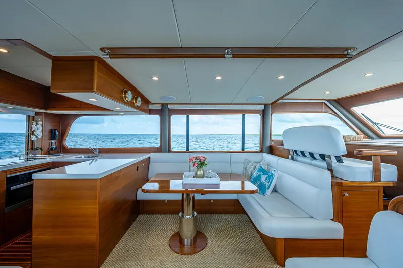 Painkiller Yacht Photos Pics Luxurious interior of 2023 Grand Banks GB60 yacht with ocean view, featuring elegant seating and decor.