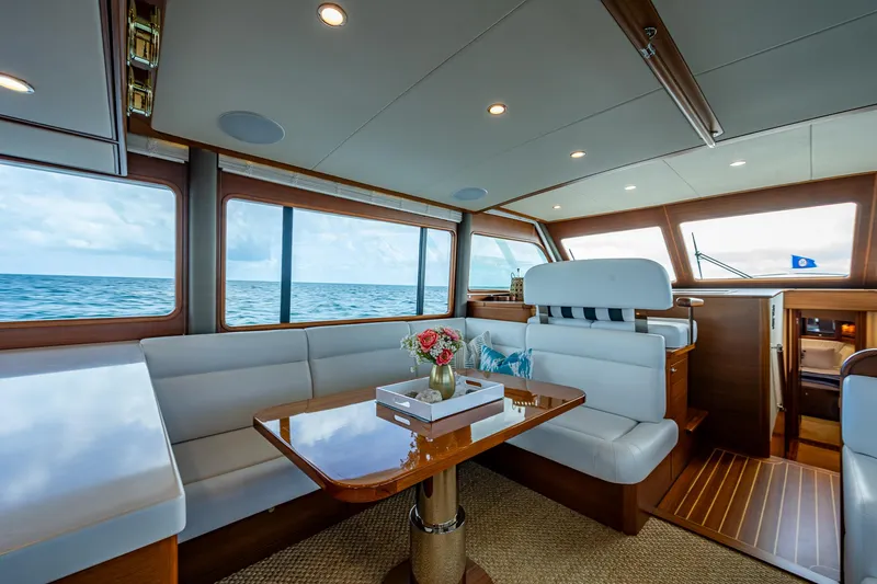 Painkiller Yacht Photos Pics Luxurious interior of 2023 Grand Banks GB60 yacht with ocean view and elegant seating area.